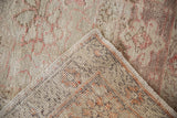 Folded corner of a distressed Turkish carpet showing even wear and hand-knotted back.