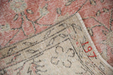 Vintage distressed Sparta carpet's natural foundation with red painted numbers and blush pink pile.