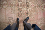 Distressed Oushak rug with a dusty blush and beige abrashed field.