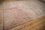 Distressed vintage Oushak carpet's dusty blush field with visible abrash texture.