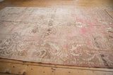 Distressed vintage Oushak rug, showing dusty blush paisley border with intact selvage.