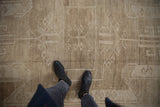 Distressed vintage Oushak carpet in neutral tones, showing abrashes and subtle geometric patterns.