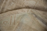 Distressed vintage Oushak carpet pile, showing even wear to knot heads and soft neutral tones.