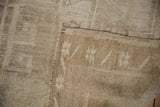 Back foundation with geometric pattern, side selvage, and distressed beige pile.