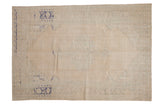 Vintage distressed Oushak carpet in sandy tones with a faint medallion and details in cobalt blue and pale green.