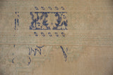 Even wear showing knot heads on a sand-colored field with distressed cobalt blue patterns.