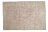 Vintage distressed Sparta carpet with a faded floral medallion in soft dusty rose and ivory.