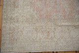 Detail of the worn, hand-knotted floral border on a distressed Turkish Sparta rug.