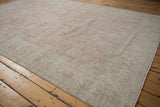 The distressed low pile and ivory floral vine border of a vintage Turkish Sparta carpet.