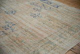 Distressed Oushak carpet with even wear to knot heads, revealing muted ivory and sage green.