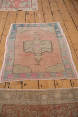 Distressed pile and fuchsia pinwheel floral motif on dusty rose vintage Oushak rug border.