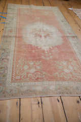 Vintage Distressed Oushak runner with abrashed blush field, Rococo floral relief, and seafoam border.