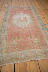Distressed vintage Oushak runner detail: faded blush field, seafoam border, and Rococo motifs.