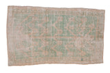 Distressed vintage Tulu rug with a geometric tree of life design in soft mint green and ivory, showing heavy, allover wear.