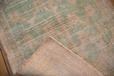 Folded corner of a distressed Tulu rug reveals its hand-woven foundation and texture.
