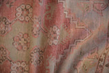 Soft, worn texture of distressed Oushak rug pile in blush and dusty jade green.