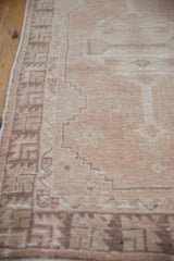 Geometric coffee brown and ivory patterns on the distressed border of a vintage Oushak rug.