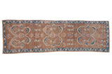 Distressed vintage Oushak runner, coffee brown field, dusty blue scrollwork, pink, and ivory motifs.