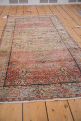 Decorative distressed Oushak rug detail showing Rococo floral relief, ribboned cloudbands, and dusty blush abrash.
