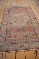 Distressed pile texture of vintage Oushak rug, with foundation visible in dusty blush tones.