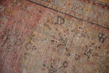 Distressed Oushak rug featuring abrashed dusty blush pile and Rococo floral motifs.