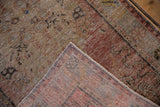 Distressed vintage Oushak rug's corner reveals worn pile, exposed knot heads, and its woven reverse.