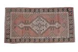 Distressed vintage Oushak rug with a stepped geometric medallion in dusty rose, sand, and charcoal.