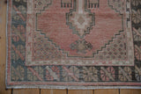 Vintage Oushak rug corner showing a stepped medallion and the evenly worn low pile.