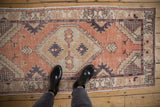 Distressed Oushak runner featuring textural pile with muted terracotta, ivory, and aubergine.