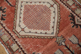 Distressed brick red field, ivory border, and dark serrated floral gul on Vintage Oushak.