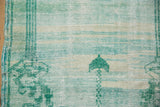 Distressed vintage Oushak rug pile with emerald green lantern motif and worn foundation.