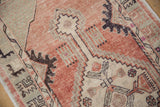 Distressed blush and pale green field with geometric floral motifs and lattice outlines.