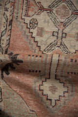 Distressed Vintage Oushak rug pile, showing stepped geometric patterns in dusty blush, pale seafoam, and aubergine.