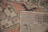 Distressed Oushak runner pile with faded geometric patterns, visible wear, and foundation.