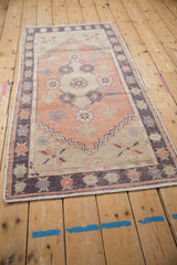 Distressed Oushak runner detail showcasing melon field, aubergine, beige floral blossom motifs.