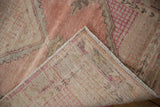 Worn pile texture and woven reverse of vintage distressed Oushak rug corner.