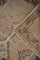 Distressed vintage Oushak rug detail, showing pile wear, geometric pattern, and woven reverse.