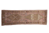 Distressed Oushak runner with dusty mauve field, double stepped medallions, and geometric border.
