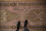 Distressed Oushak runner's dusty mauve and gold geometric pattern, showing even wear to knot heads and shoes.