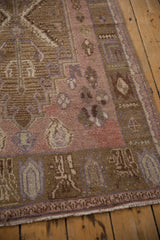 Vintage Distressed Oushak rug corner with worn pile, geometric border, and dusty mauve.