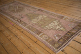 Decorative geometric border of a vintage distressed Oushak runner, showcasing faded pile texture.