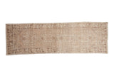 Distressed vintage Oushak runner featuring faded medallions, vine border, and 3x10 size.