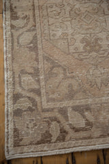 Hand-knotted Oushak runner's distressed texture showing worn beige and pale coffee brown.