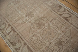 Distressed vintage Oushak runner displaying worn pile texture with subtle floral motifs in antique ivory.
