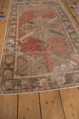 Distressed Oushak rug shows abrashed madder red field, wear, and visible foundation.