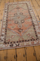 Textured pile of the distressed Oushak runner, showing floral motifs in terracotta, sage, and aubergine.