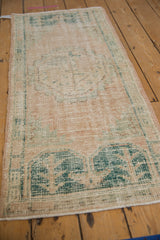 Faded beige and dark green distressed pattern showing visible wear on a vintage Oushak rug.