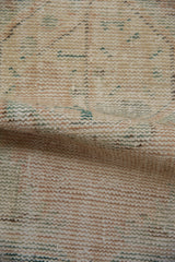 Close-up of distressed Oushak rug pile, revealing worn foundation and subtle beige-green blend.