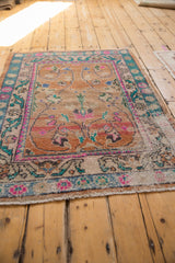 Distressed Oushak rug, faded rust field showing wear, turquoise and hot pink floral border.