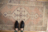 Vintage distressed Oushak runner, hexagonal stepped medallion, muted apricot, seafoam green, and ivory.